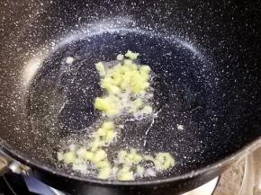 锅中倒入少许油，加入姜末，翻炒。