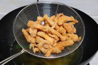 鸡柳炸至金黄色，捞出之后。把油温调高200度左右，再次放入油锅“回炸”10秒，增加这个步骤，能把油炸出来，鸡柳就不油腻，更酥脆，肉质鲜美。