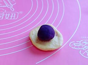 取一块面团，用掌心轻轻按压，不要太薄，放上紫薯馅，如包子手法包起来，收口捏紧。