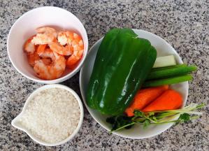 准备原材料大米、煮好的虾剥去头和皮取虾仁肉肉、青椒去籽、胡萝卜去皮、葱和香菜都洗净备用