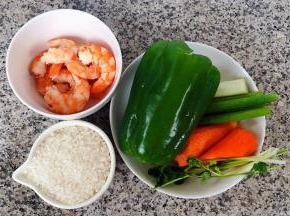 准备原材料大米、煮好的虾剥去头和皮取虾仁肉肉、青椒去籽、胡萝卜去皮、葱和香菜都洗净备用