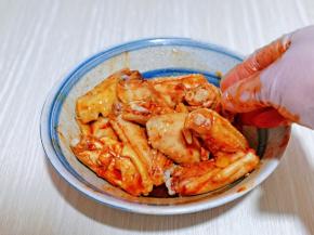 戴上食品手套，充分抓拌均匀，使每个鸡翅都吸收到酱汁。
