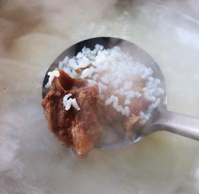大米粥煮至七成熟放入排骨中火煮10分钟