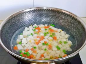 再加入什锦，(玉米粒，胡萝卜丁，豌豆）大火煮2分钟捞出淋干水分，尽量不要翻动，避免豆腐碎了。
