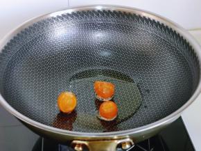 起油锅，加入咸鸭蛋黄，小火煸炒再将蛋黄铲碎。