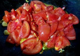 锅中倒入底油加热放入葱蒜爆香再放入番茄大火翻炒