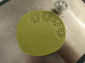 绿色面团擀薄片，用模具压出草莓叶子