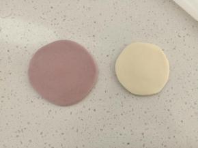 取一份紫色面团擀成薄片，再取一份白色面团擀成比紫色面团稍小一些的圆