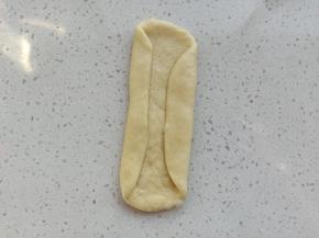 将两边收回来，用擀面杖轻轻擀一下