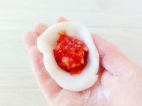 取一块面团，揉圆，按扁，放入馅料。