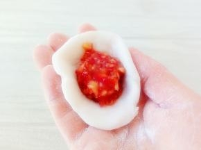 取一块面团，揉圆，按扁，放入馅料。