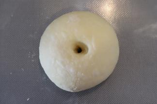 再次滚圆，手指从中间插入，慢慢转动到孔和模具中间的烟囱差不多大。