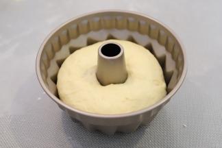 咕咕霍夫模具内放入8粒巴达木，再将面团放入模具内，发酵箱设置34度，湿度75度，二发45-50分钟。