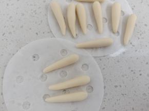 剩余的白面团，取1克左右揉圆，搓成长水滴状做耳朵