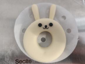 将耳朵压在甜甜圈下面就可以，再用黑色面团做出表情