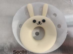 将耳朵压在甜甜圈下面就可以，再用黑色面团做出表情