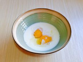 首先将牛奶倒入大口器具中，再磕入鸡蛋，用手动打蛋器打至完全融合。