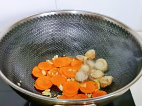 再加入胡萝卜片。腌制好的扇贝肉煸炒。