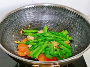 再加入焯水的荷兰豆翻炒均匀。