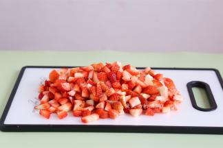 把草莓捞出沥干水分，去掉草莓蒂，切成小块，要是没料理棒就尽量切小哦~