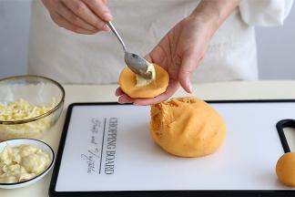 取一个大约20克的小剂子，搓圆压扁，放上适量的榴莲肉和马苏里拉芝士。