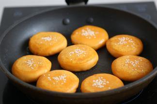 取一个红薯圆子，手轻轻压扁，沾上少许芝麻，入油锅里煎两面，金黄后翻面3次即可出锅。