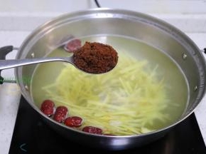这个时候的锅里水飘出一个浓香的姜味，加入2-3勺纯红糖，并且用勺子搅拌，继续小火1分钟。