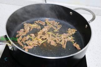 把锅洗净，烧热，倒入适量的水，放生姜、大蒜煸炒香之后，转为旺火，倒入腌制好的肉丝爆炒八成熟。