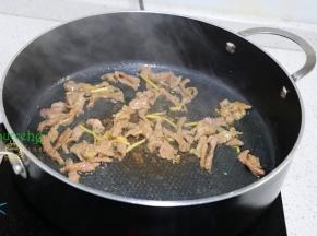 把锅洗净，烧热，倒入适量的水，放生姜、大蒜煸炒香之后，转为旺火，倒入腌制好的肉丝爆炒八成熟。