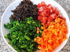 胡萝卜切成小粒和芹菜叶、木耳、腊肠放入盘中