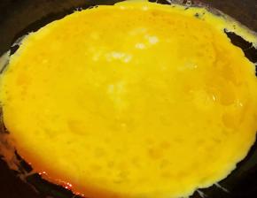 锅中倒入底油加热再倒入适量蛋糊