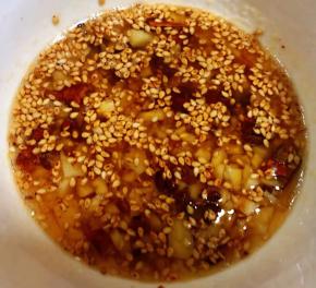 锅中倒入适量油加热放入花椒炸香取出花椒将油趁热直接倒入蒜粒碗中瞬间满屋飘香