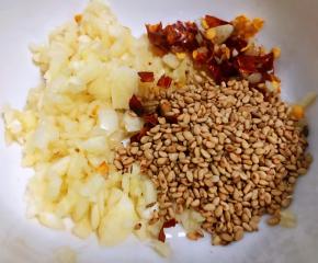 蒜粒、芝麻、干红辣椒切碎放入小碗中备用