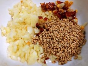 蒜粒、芝麻、干红辣椒切碎放入小碗中备用