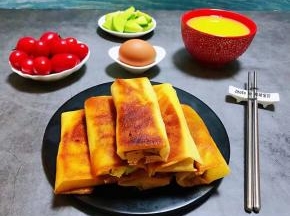 诱人的时蔬春卷装入容器中搭配鸡蛋、小米粥、萝卜小菜，水果就是标配的一餐