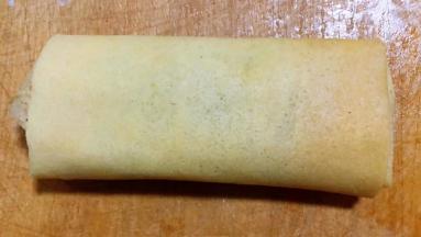 顺着一个方向将馅料包裹好卷起来