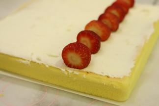 180淡奶油加细砂糖打发至裱花状态，均匀地抹在蛋糕表面，1/3处摆放上洗净的草莓。