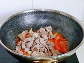 加入焯水的牛腩，翻拌至均匀，使每块牛腩吸收到番茄酱汁。