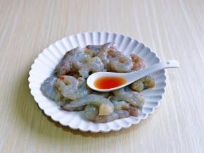 依次处理好的虾仁放入器具中，加入料酒。