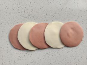 分别擀成中间厚边缘薄的面片，5个为一组，颜色交错摆好，每个面片的间距为一指宽，最后一片的距离稍微宽一些