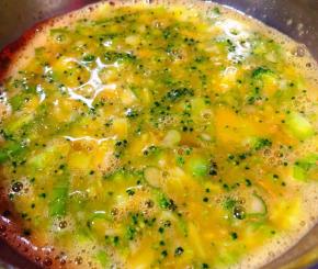 将西兰花好葱放入蛋液中同时放入盐和味精搅拌均匀入味