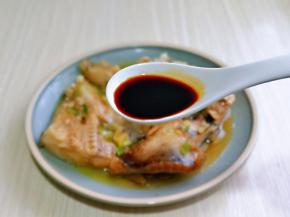 取出蒸好的鱼头，盘中的汤汁倒掉，淋上生抽，再淋上热油。(油烧热再淋)