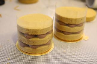 19. 放上另一片圆片，再挤可可奶油，再放上蛋糕片，四周围上透明的慕斯围边。