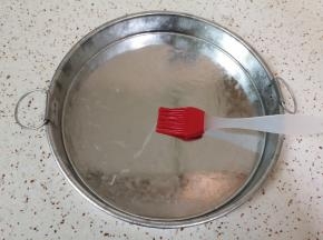锅里放水大火烧开（锅的直径要比凉皮锣锣大2-3厘米）凉皮锣锣底部和侧面刷上一层熟油。
