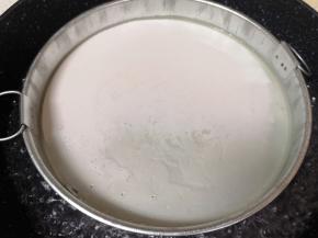 面浆水搅拌均匀舀入锣锣里面（想要凉皮厚一点就多舀一些面浆水，想要凉皮薄一点就少舀一些面浆水），将凉皮锣锣放入开水锅里来回晃一下，使凉皮薄厚均匀，盖上锅盖大火蒸至凉皮起泡就熟了（大概需要两分钟）。