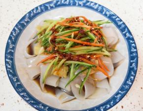 切好的凉皮放入盘子，放上黄瓜胡萝卜丝，根据自己的口味加入各种调料汁，浇上辣椒油。