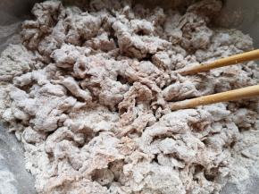 分次加入面粉里面，用筷子挑拌成絮状。