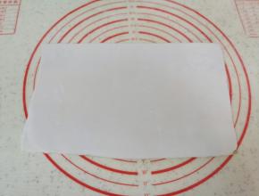 将两种糯米面团分别擀成长方形，重叠在一起，用塑料刮刀切去边缘部分，切下来的面团继续揉成团。