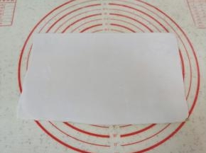 将两种糯米面团分别擀成长方形，重叠在一起，用塑料刮刀切去边缘部分，切下来的面团继续揉成团。
