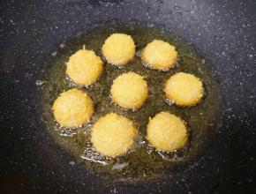 锅内倒入多一些食用油烧至6成热，放入做好的面包糠汤圆，小火炸制。